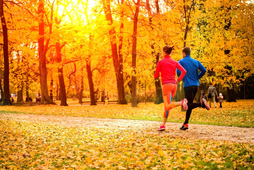 46107867 - young couple running together in park - fall nature